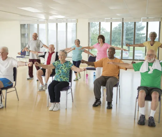Seniors working out while sitting. Enhance Fitness.